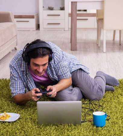 Foto de Estudiante masculino jugando juegos de ordenador en casa - Imagen libre de derechos