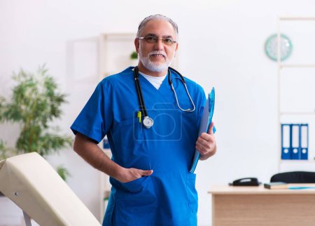 Téléchargez les photos : Médecin homme senior travaillant à la clinique - en image libre de droit