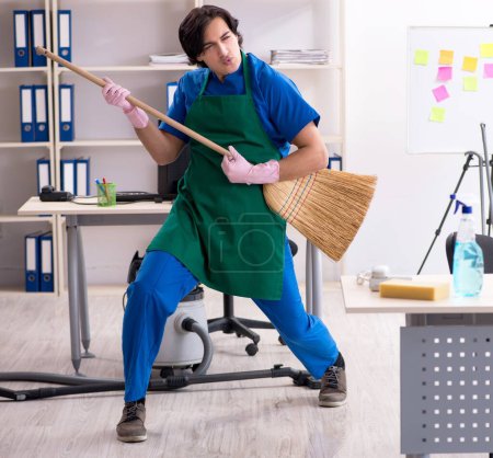 Foto de El hombre guapo limpiador profesional que trabaja en la oficina - Imagen libre de derechos