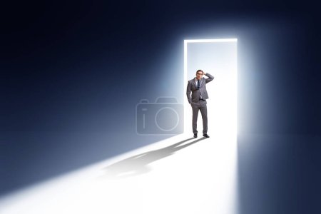 Photo for Businessman entering backlit door in the escape concept - Royalty Free Image
