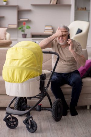 Téléchargez les photos : Homme âgé s'occupant du nouveau-né à la maison - en image libre de droit