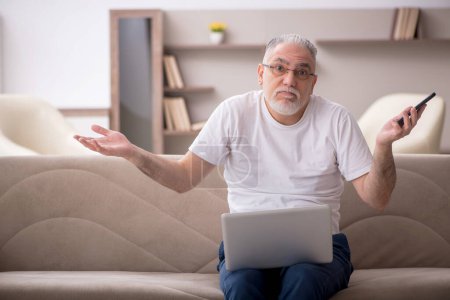 Téléchargez les photos : Old man sitting at home during pandemic - en image libre de droit