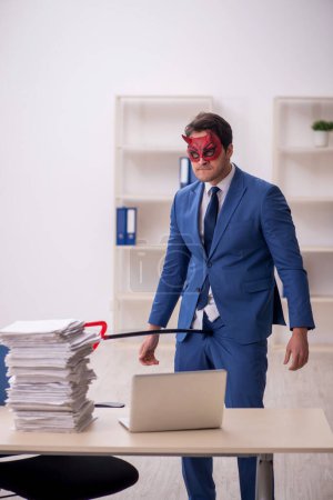 Foto de Diablo hombre de negocios descontento con el trabajo excesivo en el lugar de trabajo - Imagen libre de derechos