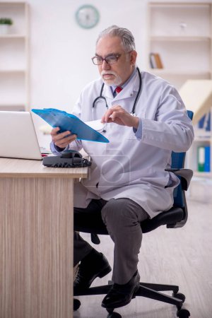 Téléchargez les photos : Vieux médecin travaillant à l'hôpital - en image libre de droit