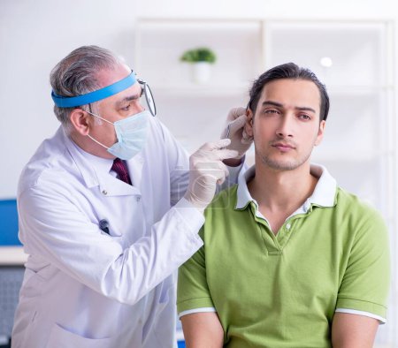 Foto de El paciente masculino que visita al médico otorrinolaringólogo - Imagen libre de derechos