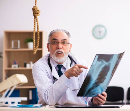 Téléchargez les photos : Vieux médecin se suicidant sur le lieu de travail - en image libre de droit