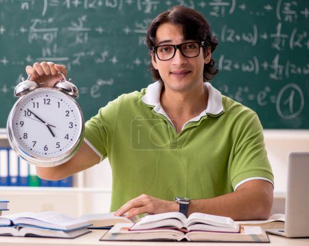 Téléchargez les photos : The handsome student in front of chalkboard with formulas - en image libre de droit