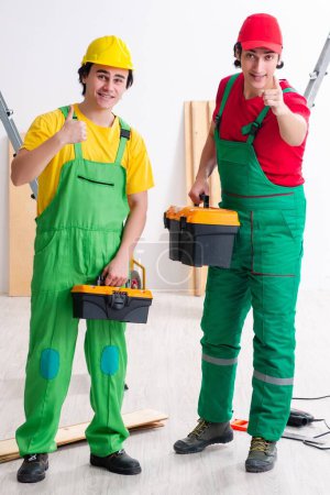 Foto de Los dos trabajadores contratistas que trabajan en interiores - Imagen libre de derechos