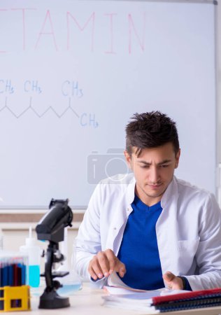 Téléchargez les photos : Le jeune chimiste assis au labo - en image libre de droit
