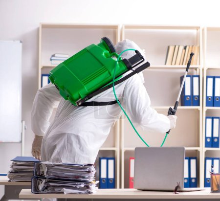 Foto de El contratista profesional haciendo control de plagas en la oficina - Imagen libre de derechos