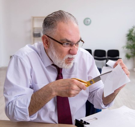 Photo for Aged employee unhappy with excessive work - Royalty Free Image