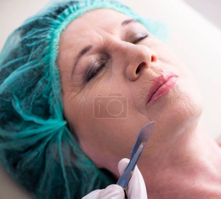 Téléchargez les photos : La vieille femme visitant le médecin masculin pour la chirurgie plastique - en image libre de droit