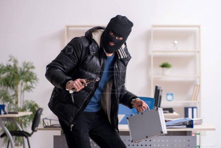 Photo for Young male burglar in the office room - Royalty Free Image