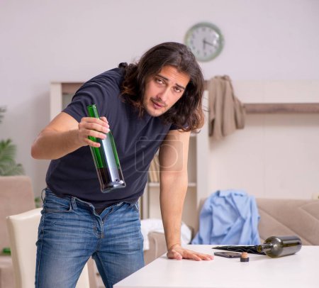 Foto de Joven bebiendo alcohol en casa - Imagen libre de derechos