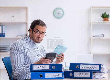 Photo for Young bookkeeper calculating tax payments in the office - Royalty Free Image