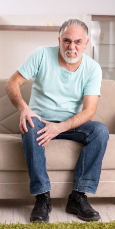 Téléchargez les photos : Le vieil homme barbu blanc qui souffre à la maison - en image libre de droit