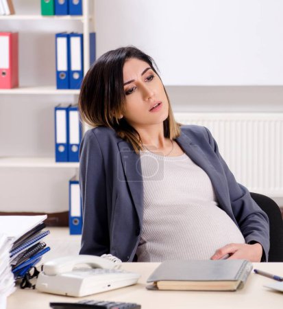 Photo for The young pregnant employee working in the office - Royalty Free Image