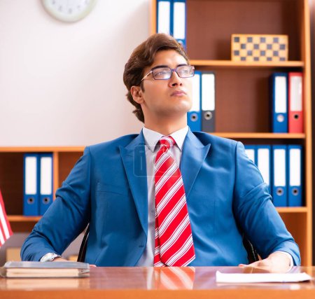 Photo for The young handsome politician sitting in office - Royalty Free Image