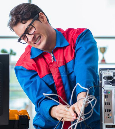 Photo for The computer repairman working on repairing computer in it workshop - Royalty Free Image