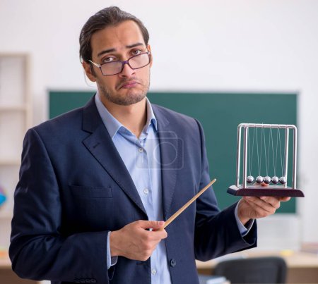 Photo for Young teacher physicist in front of green board - Royalty Free Image