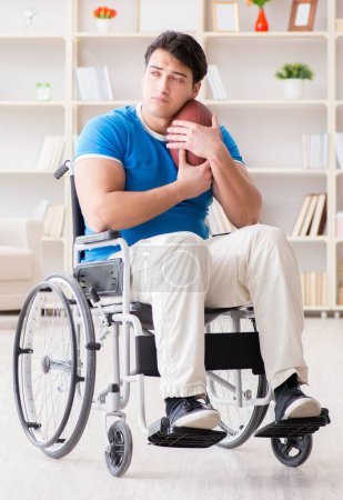 Foto de El joven jugador de fútbol americano recuperándose en silla de ruedas - Imagen libre de derechos