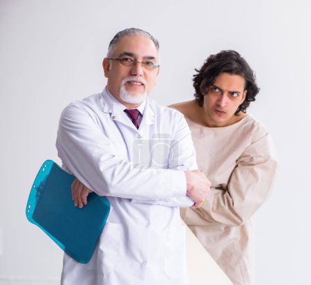 Foto de El psiquiatra médico anciano examinando a un paciente joven - Imagen libre de derechos