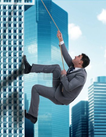 Téléchargez les photos : L'homme d'affaires en défi concept escalade gratte-ciel - en image libre de droit