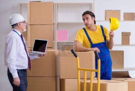 Téléchargez les photos : Les déménageurs professionnels qui déménagent à la maison - en image libre de droit