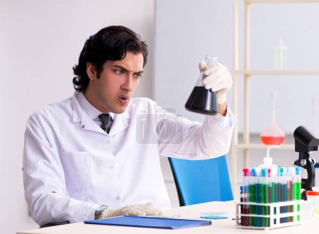 Photo for The young handsome chemist working in the lab - Royalty Free Image
