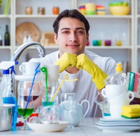 Foto de El hombre disfrutando de las tareas de lavado de platos en casa - Imagen libre de derechos