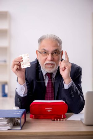 Téléchargez les photos : Vieil homme d'affaires employé se sentant mal dans le bureau - en image libre de droit