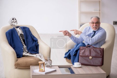 Photo for Old male boss and skeleton in business meeting concept - Royalty Free Image