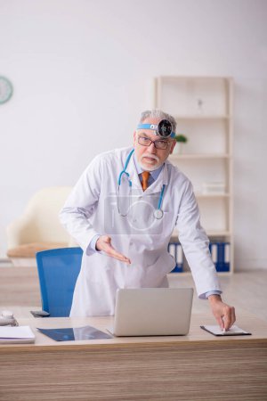 Photo for Old doctor otologist working at the hospital - Royalty Free Image