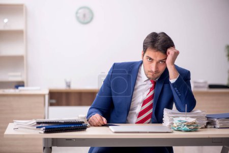 Photo for Young male employee sitting at workplace - Royalty Free Image
