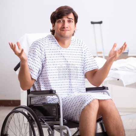 Téléchargez les photos : Le jeune bel homme en fauteuil roulant à l'hôpital - en image libre de droit