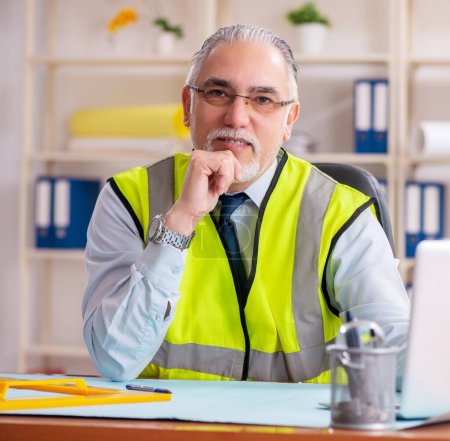 Photo for The aged construction engineer working in the office - Royalty Free Image