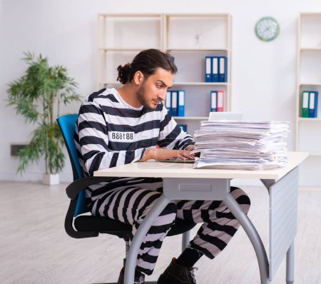 Téléchargez les photos : Le jeune employé se sent prisonnier au travail - en image libre de droit