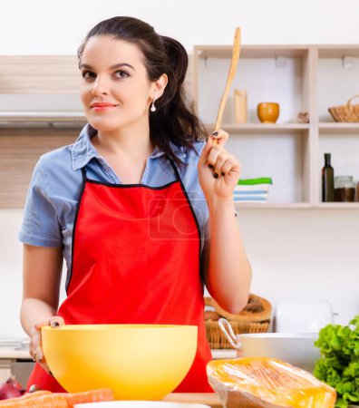 Foto de La joven con verduras en la cocina - Imagen libre de derechos