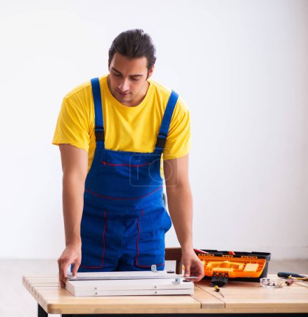 Foto de Joven carpintero masculino trabajando en casa - Imagen libre de derechos