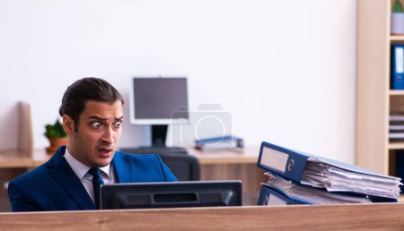 Foto de Hombre empleado infeliz con el exceso de trabajo en la oficina - Imagen libre de derechos