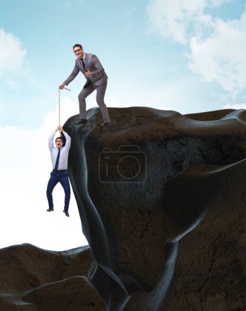 Photo for The businessman helping colleague with rope - Royalty Free Image