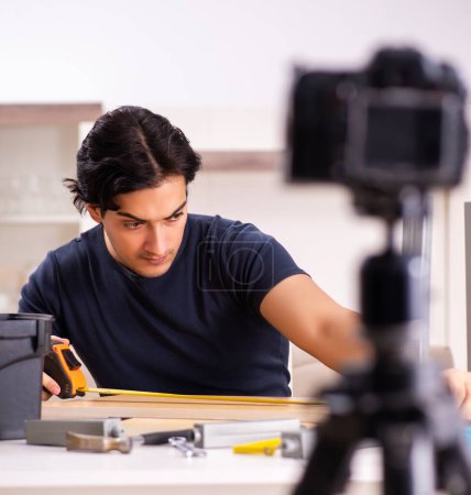 Téléchargez les photos : Le jeune réparateur masculin enregistre une vidéo pour son blog - en image libre de droit