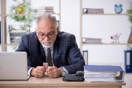 Foto de Viejo empleado sintiéndose mal en la oficina - Imagen libre de derechos