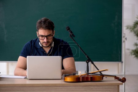 Photo for Young music teacher sitting in the classroom - Royalty Free Image