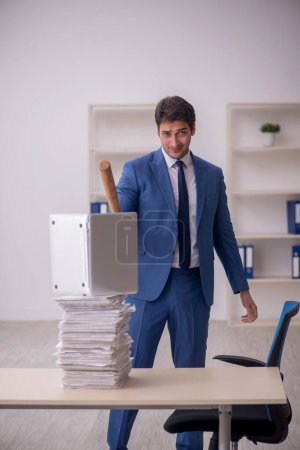 Téléchargez les photos : Jeune employé mécontent du travail excessif au bureau - en image libre de droit