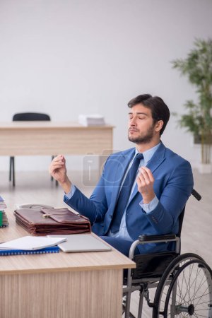 Photo for Young businessman employee in wheel-chair - Royalty Free Image