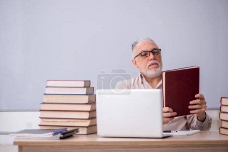 Photo for Old teacher sitting in the classroom - Royalty Free Image