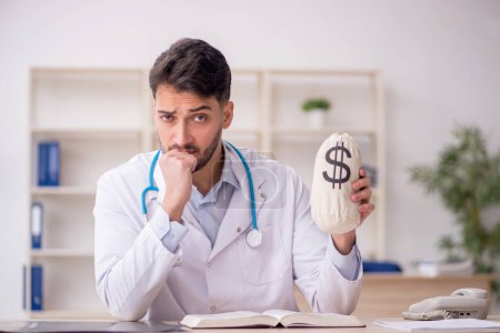 Photo for Young doctor in remuneration concept - Royalty Free Image