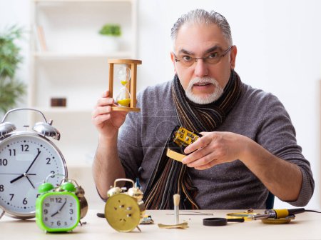 Téléchargez les photos : Vieil horloger travaillant dans l'atelier - en image libre de droit