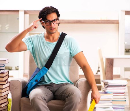 Téléchargez les photos : L'étudiant mâle avec de nombreux livres à la maison - en image libre de droit